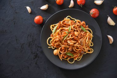 Domates soslu lezzetli makarna. Kıymalı domuz eti, mantar ve siyah masada fesleğen..