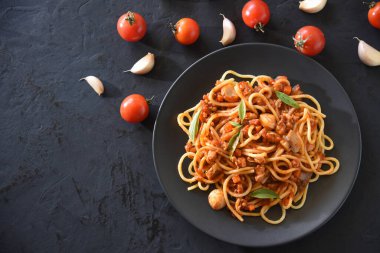 Domates soslu lezzetli makarna. Kıymalı domuz eti, mantar ve siyah masada fesleğen..