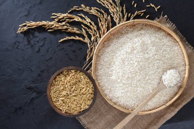 Paddy and rice in baskets placed on a black background. clipart