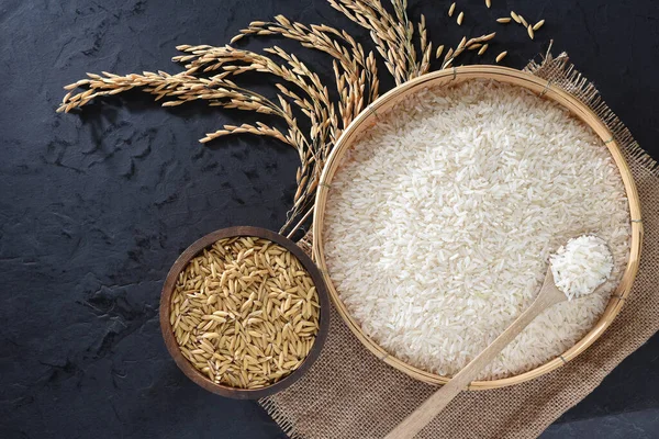 stock image Paddy and rice in baskets placed on a black background.