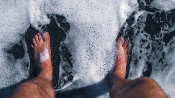 浜辺の水の中に立つ裸の足のシネマグラム — ストック動画