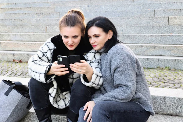 Due Donne Sedute Fuori Guardare Loro Telefono — Foto Stock
