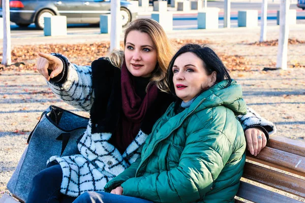 Dos Mujeres Sentadas Afuera Banco Con Abrigos Mirando Algo —  Fotos de Stock