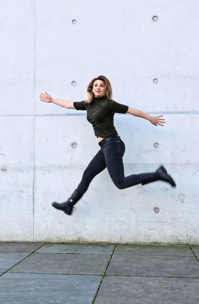 Mujer Joven Ropa Negra Saltando Frente Pared Gris Fotos de stock libres de derechos