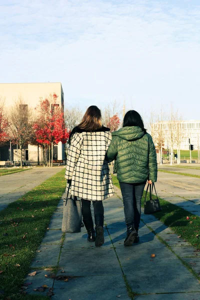 在城市里 两名身穿外套的妇女沿着街道走着 图库图片
