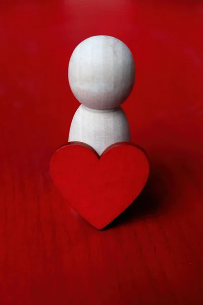 Holzfigur Und Rotes Herz Auf Rotem Hintergrund Stockfoto