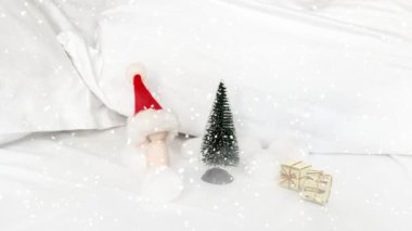 Minyatür figürler ve beyaz çarşaflı küçük Noel Baba. 