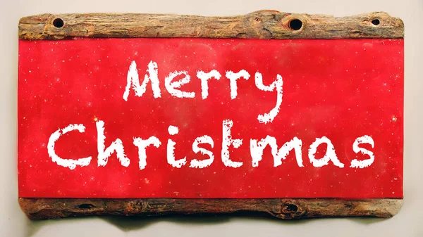 赤い背景にメリークリスマスという言葉で木製の看板 ロイヤリティフリーのストック画像