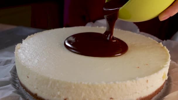 液体チョコレートのクローズアップケーキの上に注ぎました 行動だ 溶かした液体チョコレートがココナッツケーキの上に広がります チョコレートシロップでコーティングケーキ — ストック動画