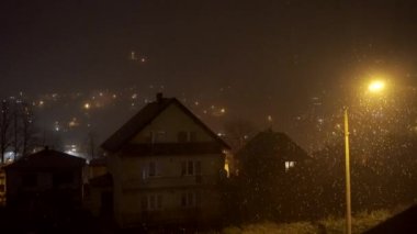 Night view of A shaped houses during snowfall and foggy weather. European town