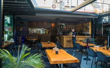 Alanya, Türkiye - 12 Eylül 2021: Yemek masası olan bir Türk restoranı ve erkek garsonla sandalyeler