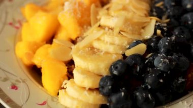 Meyve salatası, kivi, yaban mersini ve muz tabakta servis edilir.