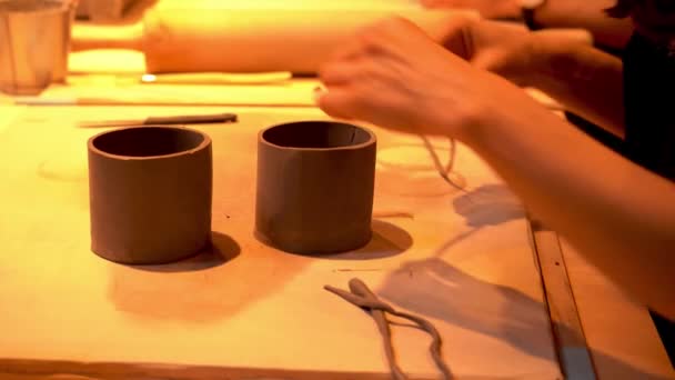 手作りのカップや小さな容器のマグカップを作るクローズアップ女性のセラミストの手 陶芸スタジオの女性の陶芸工芸クラフト粘土テーブルウェア セラミックワークショップでの作業プロセス — ストック動画