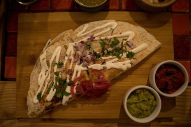 Siyah tahtada tavuk ve soslu Quesadilla, koyu kırsal beton arka plan