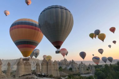 Kapadokya, Türkiye - 14 Eylül 2021: Peri bacalı Goreme 'in doğal parkı, tarihi ve manzarası üzerinde uçan çok sayıda sıcak hava balonunun insansız hava görüntüsü