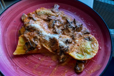 İspanyol restoranında servis edilen mantar soslu patates ve peynirli börek.