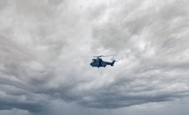 Spanish Air Force AS.332 Puma military combat search and rescue helicopter on the tarmac of Torrejon airbase flying above sea during cloud thunderstorm weather clipart