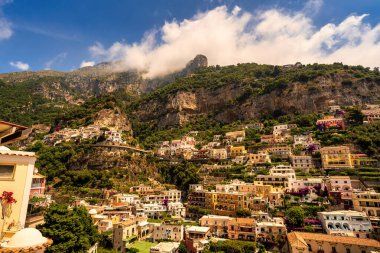 İtalya 'nın Amalfi Sahili yakınlarındaki Positano köyünün manzarası tepenin üstünde bulut oluşumuyla