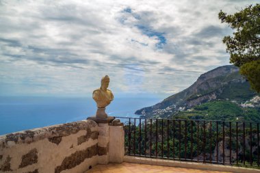 Sonsuzluk Terası, İtalya Ravello 'daki Villa Cimbrone Villa Bahçeleri: Dağları, yeşilliği ve bulutlu bir gökyüzünün altında sakin bir denizi olan çarpıcı bir kıyı manzarasına bakan heykel..
