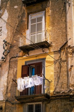 Kurutucu giysiler tutan balkonlu eski bir binanın güzel manzarası. Kırsal görünüm, tipik bir Akdeniz manzarası sergileyerek kent yaşamını ve geleneğini ön plana çıkarıyor..