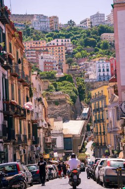 Napoli, İtalya - 22 Haziran 2024: Tarihi Castel Sant 'Elmo' nun renkli tepe binalarının üzerinde sergilendiği canlı bir sokak, şehrin canlı atmosferinin özünü yakalıyor.