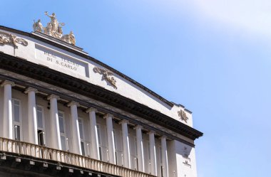 Napoli, İtalya - 24 Haziran 2024: Napoli, İtalya 'da açık mavi bir gökyüzü altında Real Teatro di San Carlo' nun zarif mimari detayları. Tarihi İtalyan tiyatro mimarisinin çarpıcı bir örneği..
