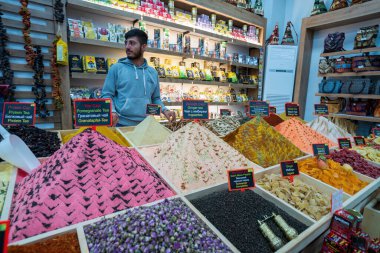 Taraf, Türkiye - 16 Eylül 2021: Türk pazarında canlı renkli baharat ve çayların sergilenmesi, dükkana katılan bir satıcının zengin yerel aromalar ve aromalar sergilemesi.