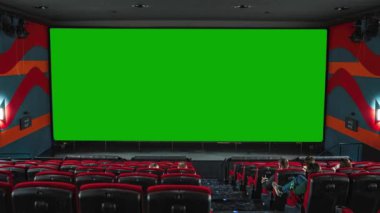 İnsanlar sinema sandalyelerinde oturup büyük yeşil ekran, sinema salonu, Yeşil Ekran Sinema Projeksiyonu 'nu seyrediyorlar.
