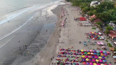 Bali 'deki Seminyak Sahili' nin üzerinde süzülen bu drone görüntüleri, plaj kafeleri, kristal berrak sular ve güneş, kum ve hoşgörü için ideal tatil beldesi olan sahil şeridi üzerindeki cazibesini vurguluyor..