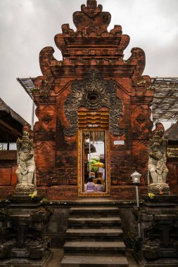 A detailed view of a traditional Balinese temple featuring intricate carvings, statues, and cultural ambiance. This setting captures the essence of Indonesia's architectural and spiritual heritage. clipart