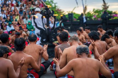 Bali, Indonesia - November 30, 2023: Cultural performance in Bali showcasing a traditional ritual with performers in vibrant attire, chanting in harmony. clipart