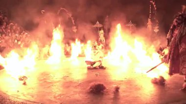 Bali, Endonezya - 29 Kasım 2023: Mor alacakaranlık, Kecak ramayana gösterisi sırasında Hanuman 'ın dört bir yanında ateşle tapınak zeminini kucaklarken, antik karakter maskeli dansla canlanıyor 