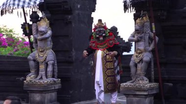 Bali, Endonezya - 29 Kasım 2023: Mor alacakaranlık Kecak ramayana performansı sırasında tapınak zeminini kucaklarken antik karakter maskeli dansla canlanıyor