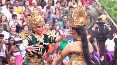 Bali, Endonezya - 29 Kasım 2023: Bali, Endonezya 'da bir kültürel dans gösterisi, katılımcı kitlesi tarafından çevrelenmiş geleneksel kostüm ve hikaye anlatımları sergileniyor