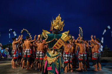 Bali, Endonezya - 23 Kasım 2023: Kecak dansı, altın kaplamalı bir savaşçı Ram olarak gözler önüne seriliyor, çıplak göğüslü sanatçılar hipnotize edici bir tezahürata önderlik ediyor, antik bir Hint destanını tekrarlıyor.