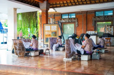 Bali, Endonezya - 23 Kasım 2023: Sanatçılar güzel dekore edilmiş bir stüdyoda oturuyorlar, ayrıntılı modeller hazırlıyorlar, geleneksel Endonezya tekniklerini canlı ve kültürel bir ortamda sergiliyorlar.