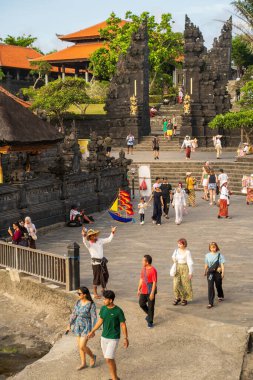 Bali, Endonezya - 11 Kasım 2023: İkonik taş mimarisi ve uluslararası turistlerin kültürel deneyimler için toplandığı kendine özgü çatıları olan Bali deniz tapınağı