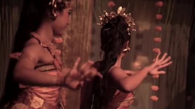 Bali, Endonezya - 12 Aralık 2023: Halkın sanatsal gelenekleri ve karmaşık dekorasyonları ile canlı giyinmiş bir sanatçı tarafından gerçekleştirilen geleneksel kültürel dansın büyüleyici bir gösterisi.