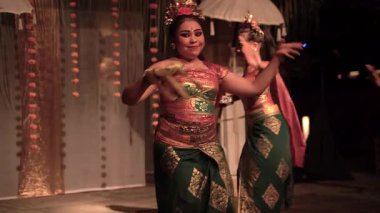 Bali, Endonezya - 12 Aralık 2023: Endonezya 'nın geleneksel Endonezya dansının canlı bir tasviri zarif giyimli bir dansçı tarafından bir törende sergilendi, kültürel mirası sergiledi.