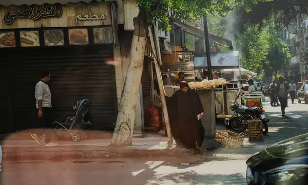 Kahire, Mısır - 11 Eylül 2023: Mısır 'da bir yiyecek tezgahı, yayalar ve şehir yaşamını gösteren canlı bir sokak sahnesi. Mahallenin eşsiz atmosferi ve günlük rutinleri