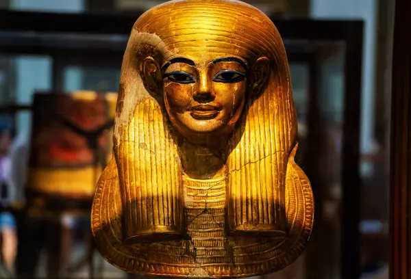 Eski Mısır sanatının başyapıtı Tutankamon 'un ikonik altın cenaze maskesi müze ışıkları altında parıldıyor..