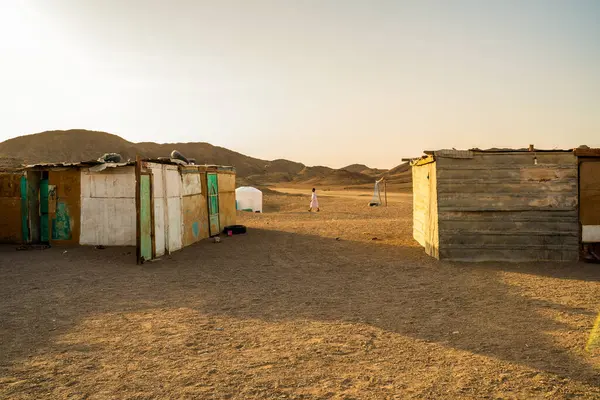 Mısır 'ın çorak topraklarında, sıcak güneş ışığı altında, uzak tepeleri olan iki el yapımı kır evi..