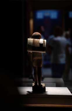 Kahire, Mısır: Eski Mısır heykelciği bir çanta taşıyor, erken dönem çanta tasarımı sergileniyor. Eser, antik dünyada Mısır 'ın zengin tarihi ve zanaatkarlığını ön plana çıkarıyor.