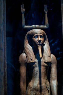 Kahire, Mısır - 9 Eylül 2023: Eski Mısır ahşap lahit kaldırılmış kolları ve müze vitrininde ayrıntılı yüz hatları ile