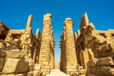 Luxor Mısır antik tapınak kompleksi çökmüş firavun sütunlarını ve arkeoloji sahasındaki aşınmış kumtaşı yapılarını gösteriyor.