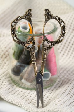 Makas ve iplik makaralı bir kavanoz.