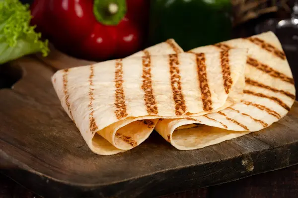 Tahtada mangalda kızartılmış tortilla var.