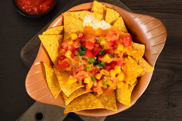 Erimiş çedar peyniri ve salsa soslu çıtır tortilla cipsi.