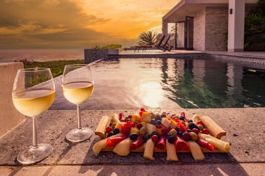 Yüzme havuzunun yanında yemek tabağı ve şampanya bardakları. 