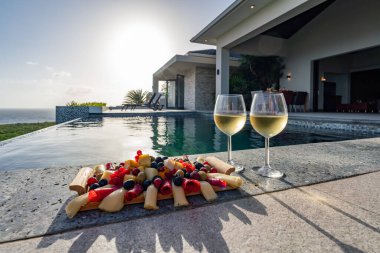 Yüzme havuzunun yanında yemek tabağı ve şampanya bardakları. 